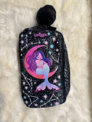Glittery black Smiggle pencil case with a magical graphic of a mermaid sitting on a pink and purple crescent moon against a cosmic star background. The zipper pull features a fluffy black pom-pom